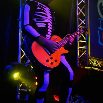Alan playing guitar, dressed as a skeleton.