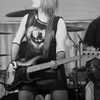 Ann playing Richard's bass and pulling a funny face. Black and white.