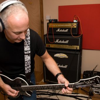 Neil playing guitar in the studio.