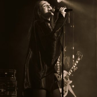Ann singing on her mic, black and white.