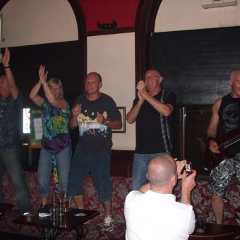 The crowd at the Old Bank Inn, Blackpool, dancing on the seats next to Neil playing guitar.