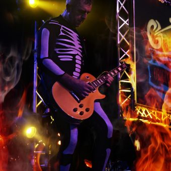Alan playing guitar, wearing a skeleton costume.