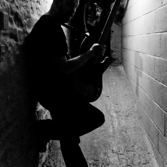 Richard standing in a corridor at the studio, silhouette.